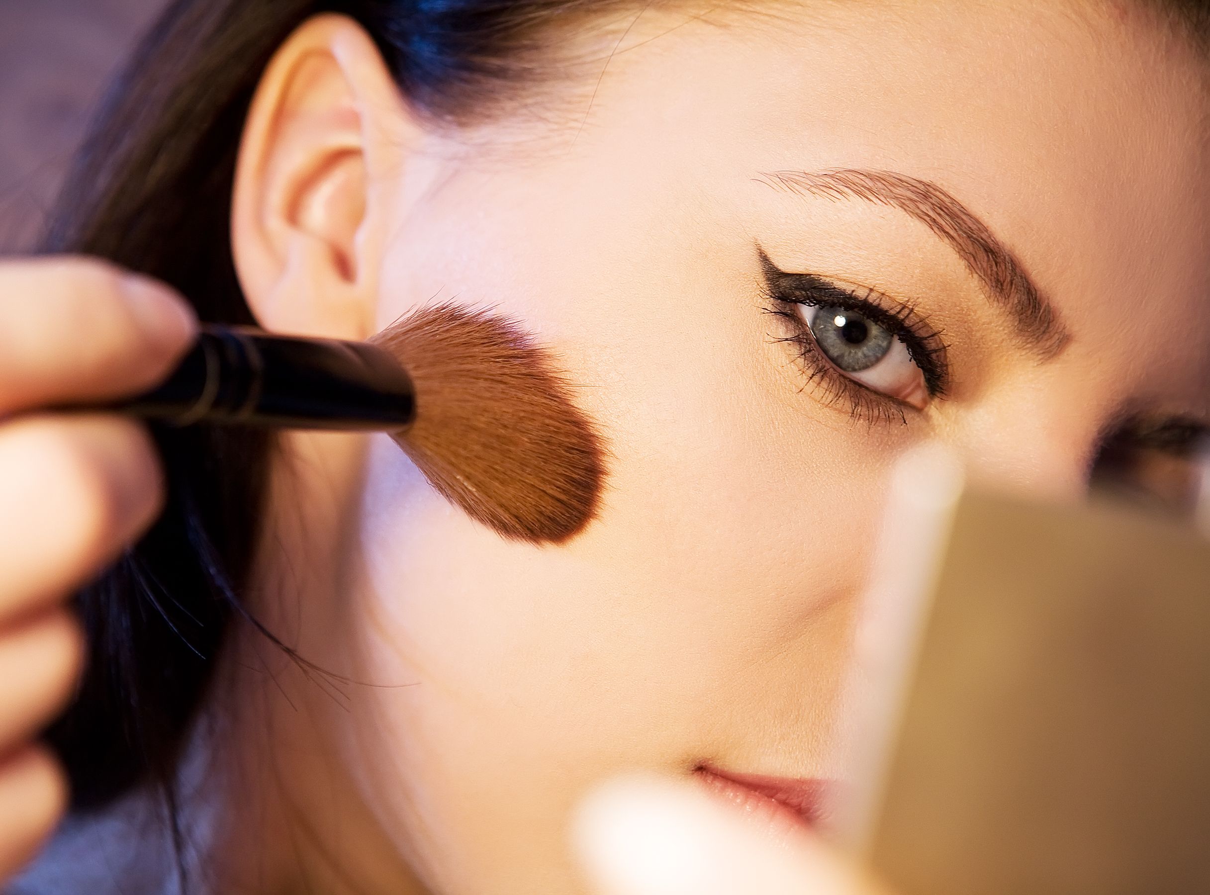 Femme appliquant maquillage avec pinceau