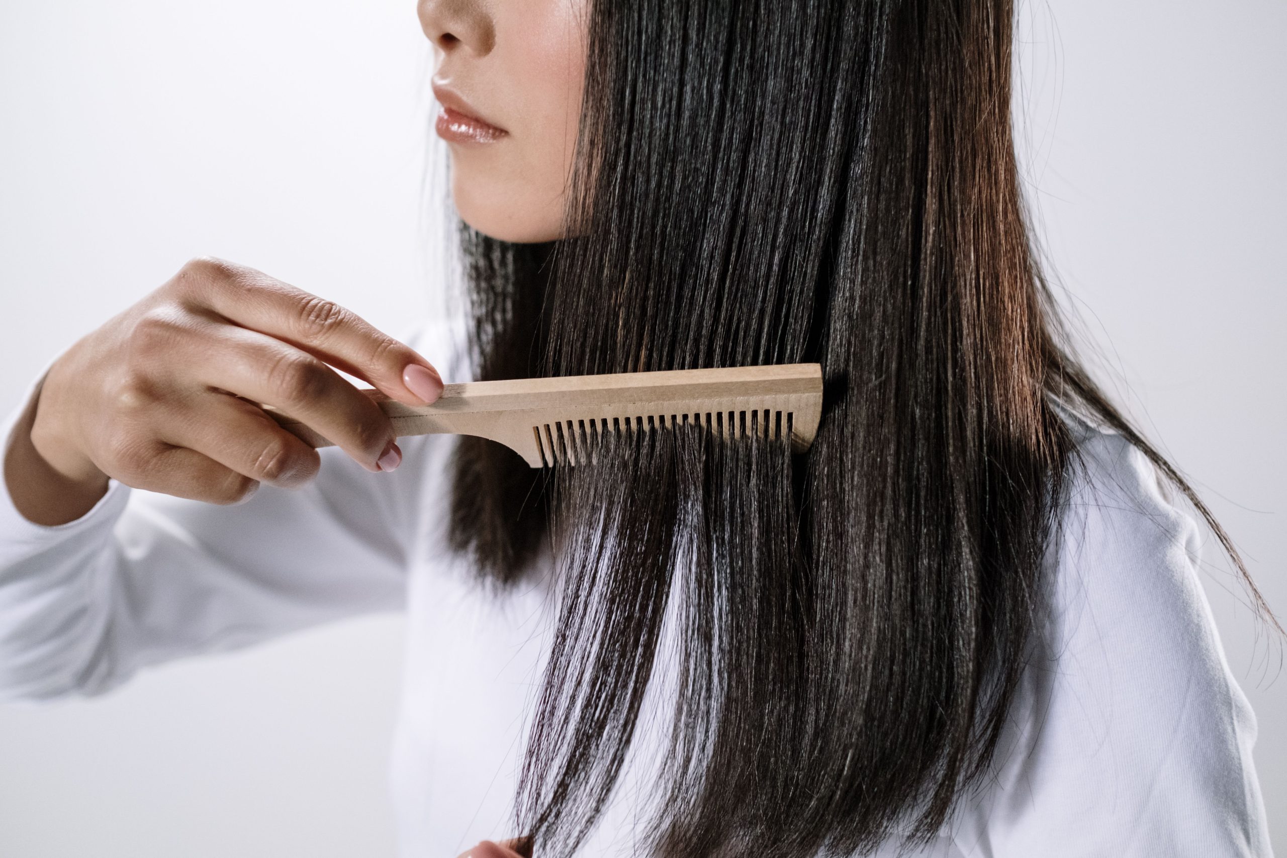 Femme peignant ses cheveux avec peigne bois