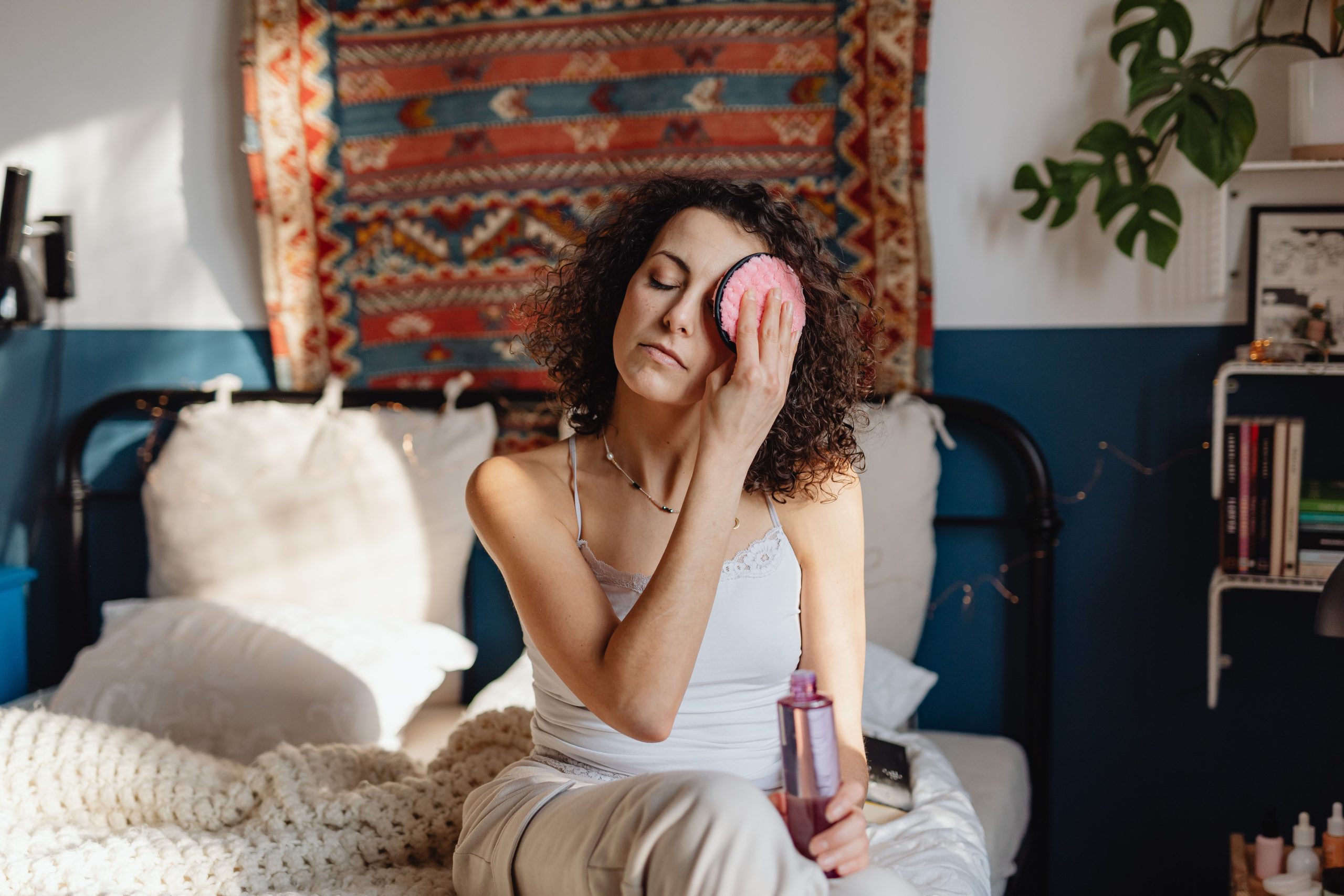 Femme retire maquillage avec disque coton