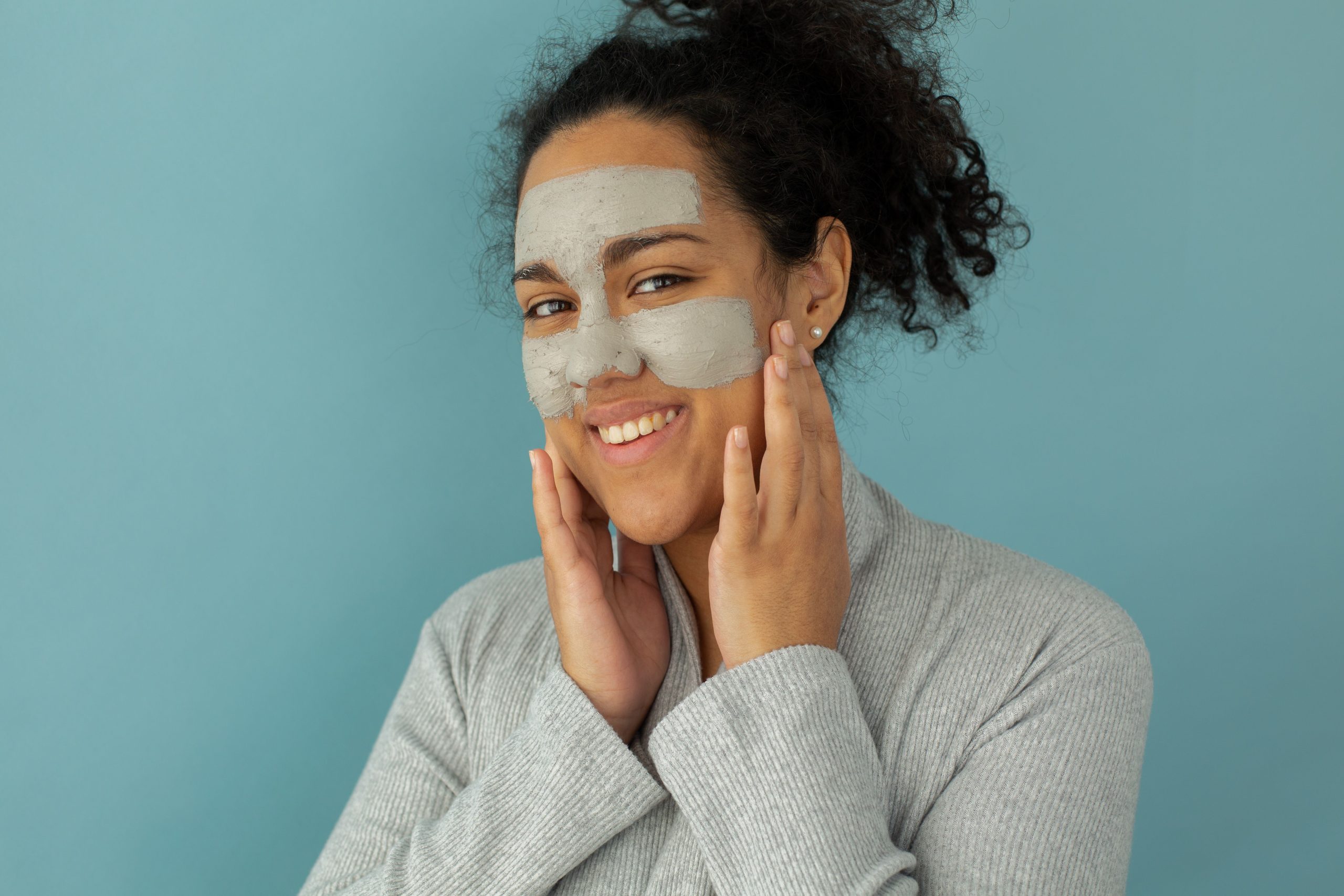 Femme touchant visage avec masque nettoyant