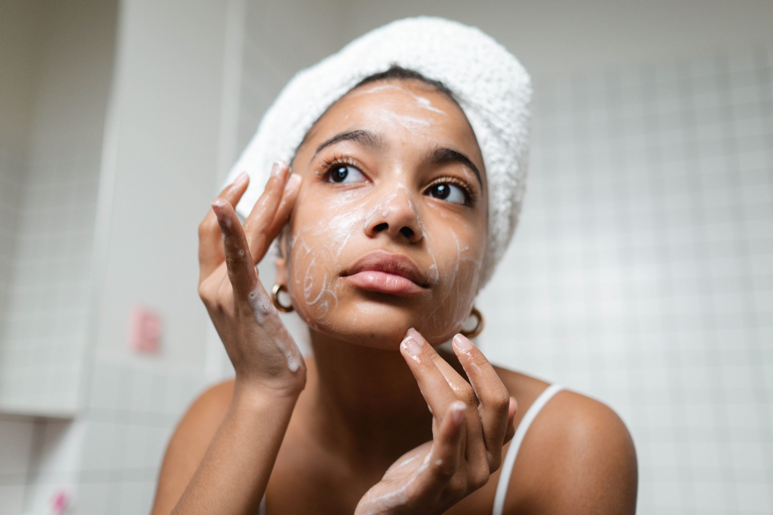 Femme appliquant crème visage salle bain