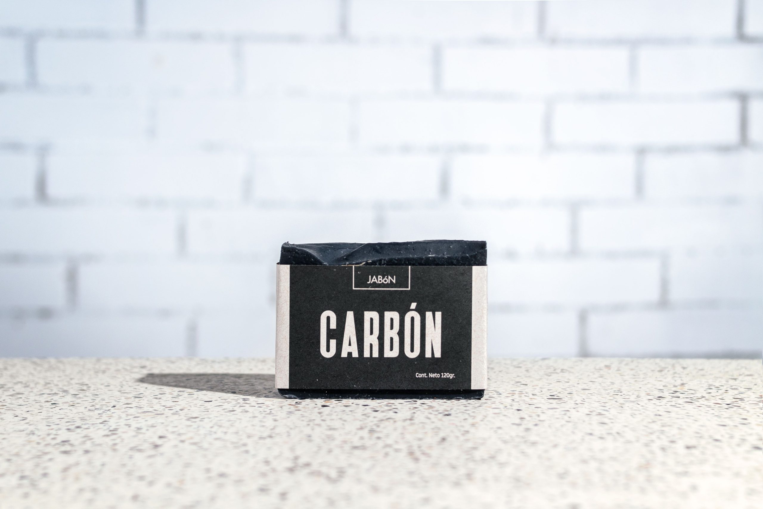 Savon charbon artisanal sur surface texturee