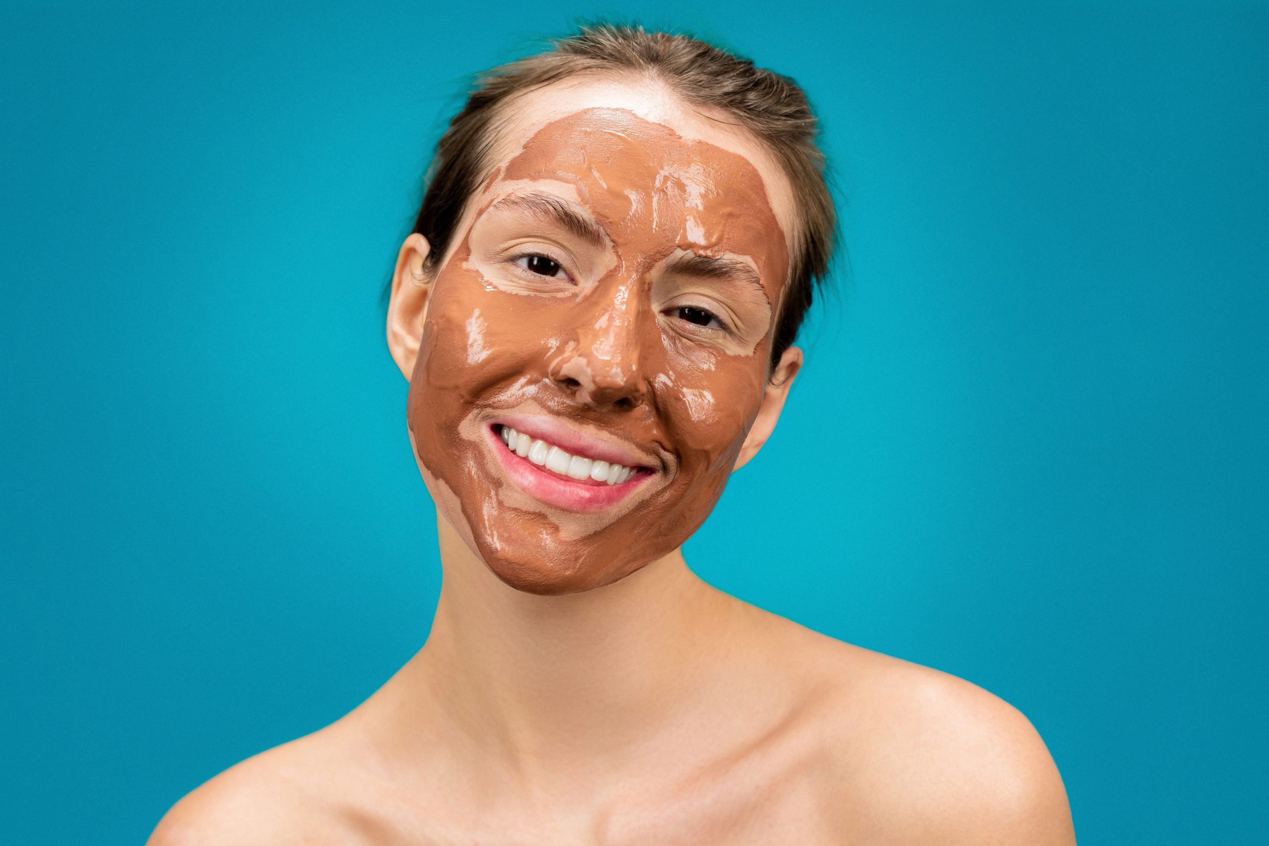 Femme souriante portant un masque hydratant argileux