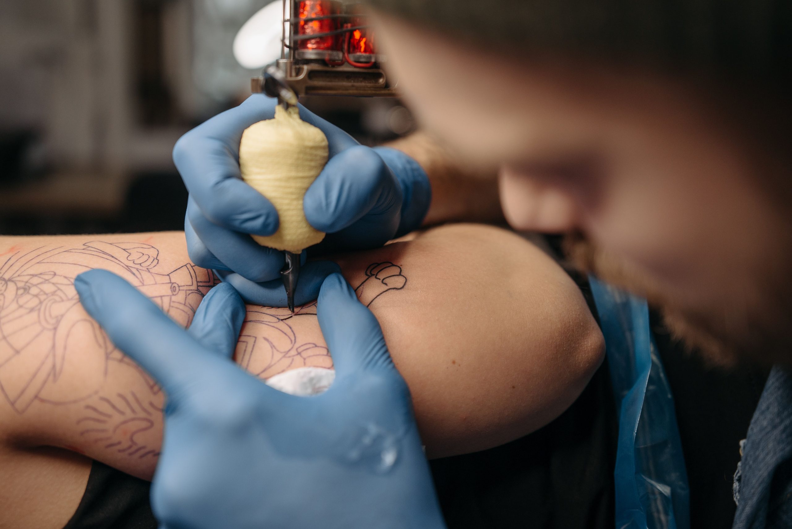 Gros plan du tatoueur travaillant sur un tatouage detaille