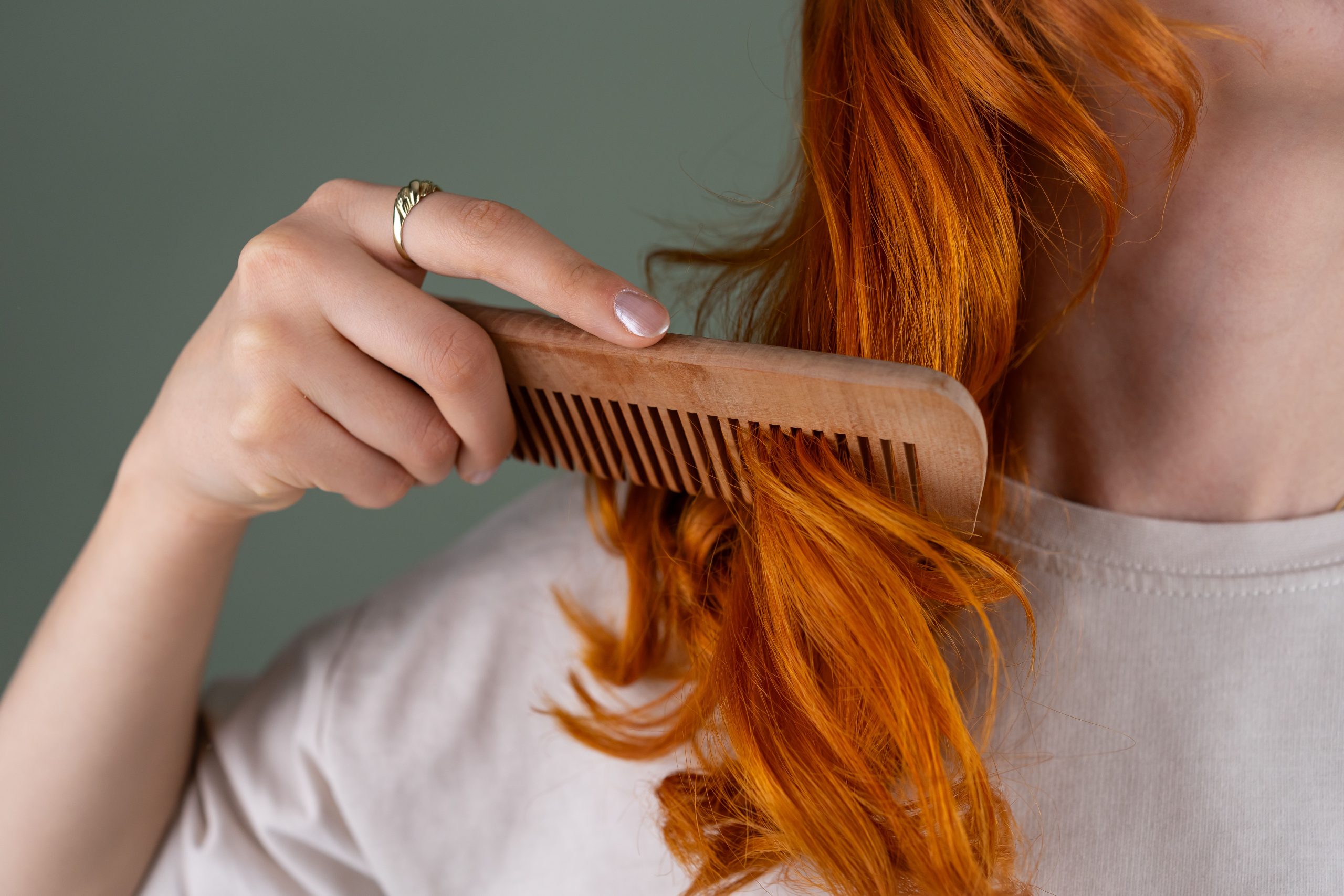 Femme peigne cheveux rouges ondules peigne bois.