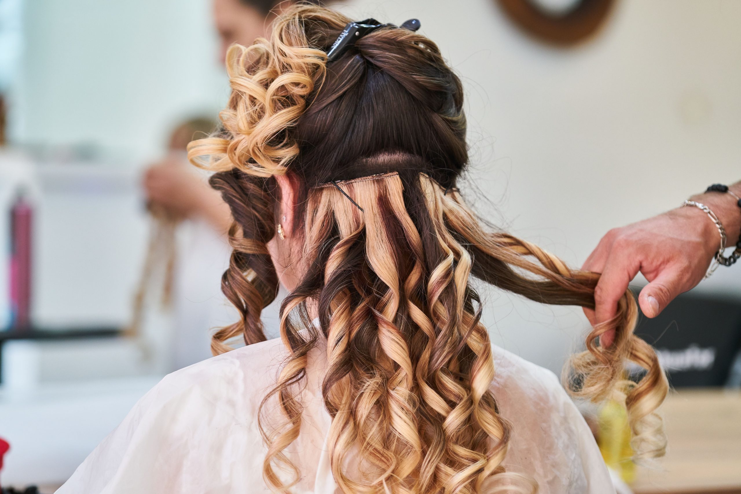 Coiffeuse perfectionnant les boucles en salon