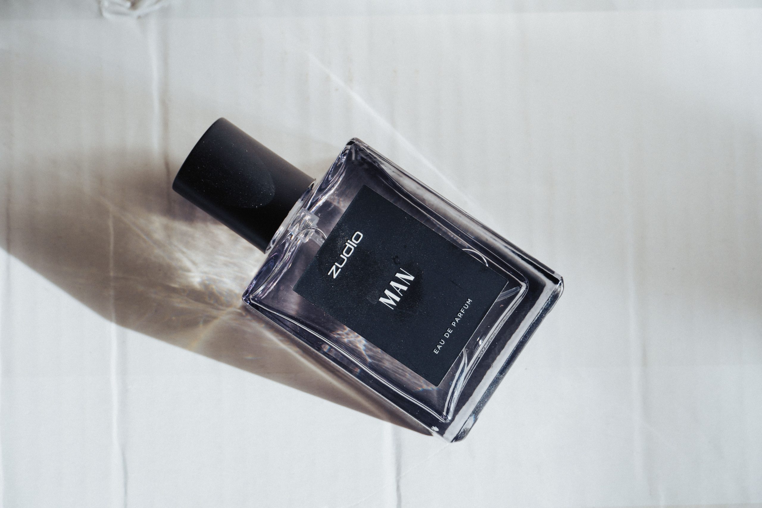 Parfum homme minimaliste ombre surface blanche