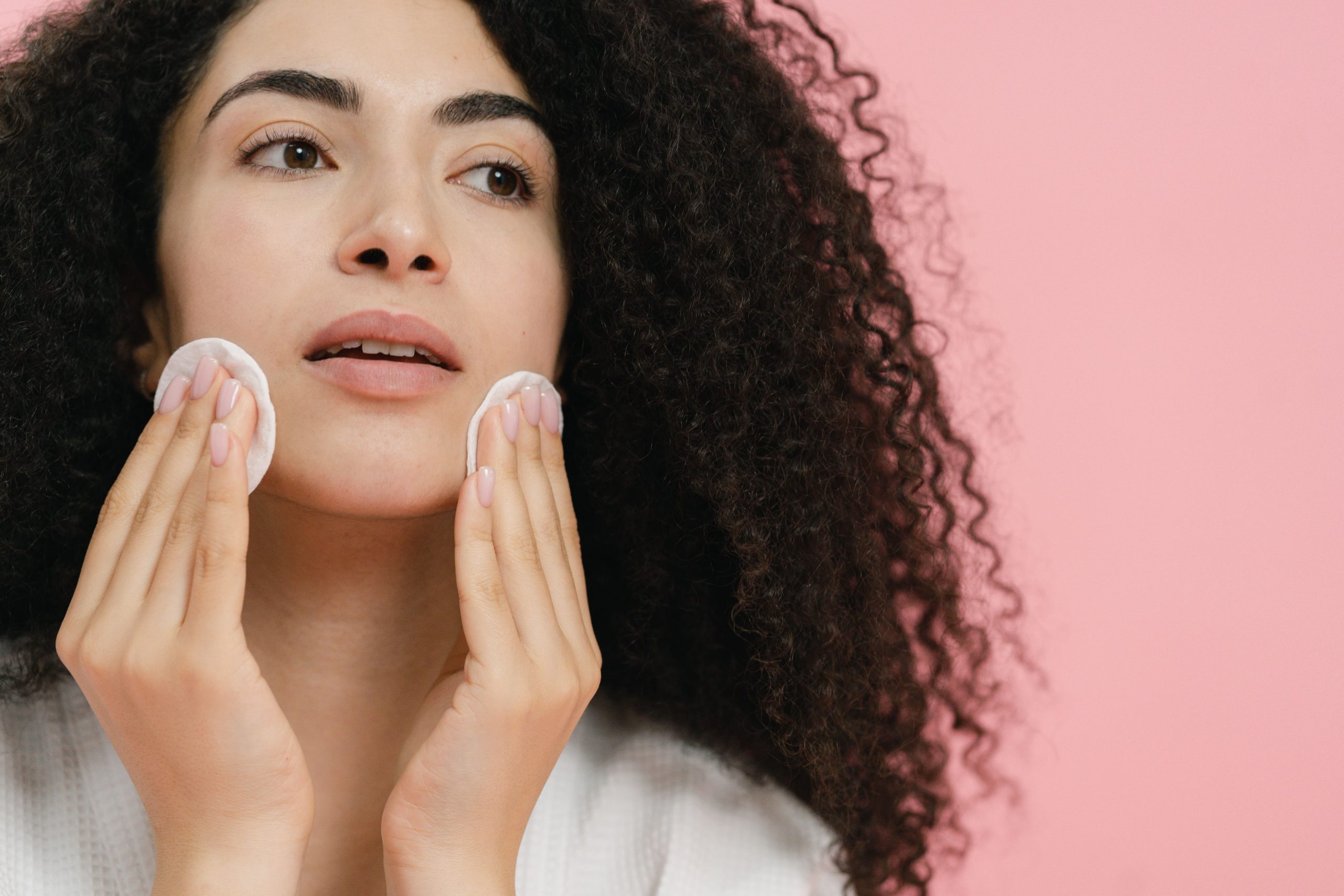 Femme nettoyant visage avec disques coton