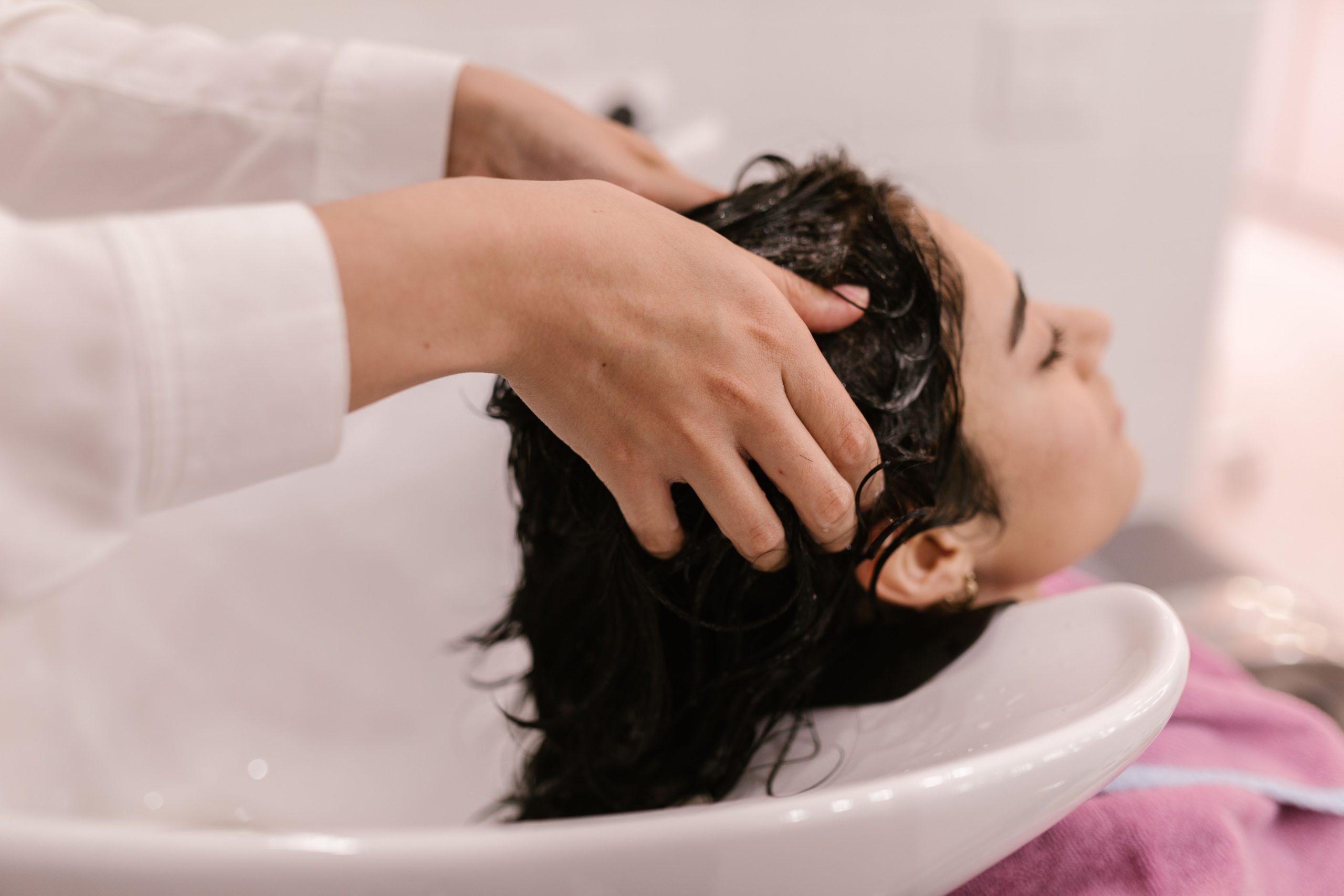 Femme relaxée pendant un lavage capillaire au salon.
