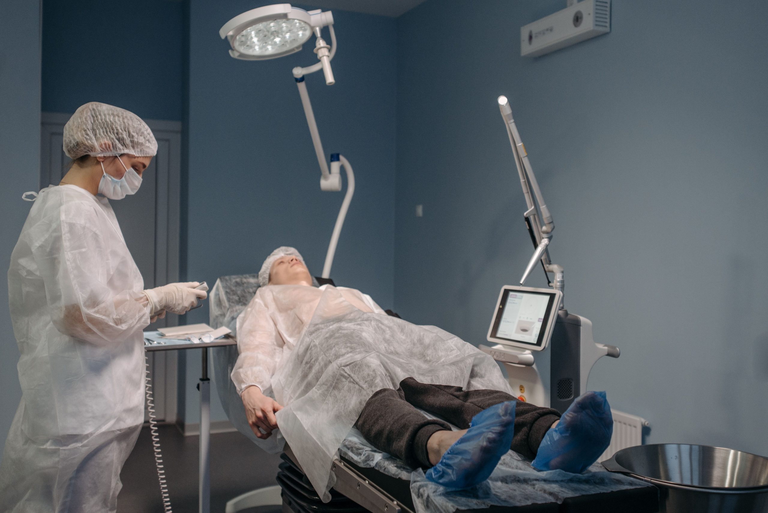 Professionnel réalisant procedure laser en bloc opératoire