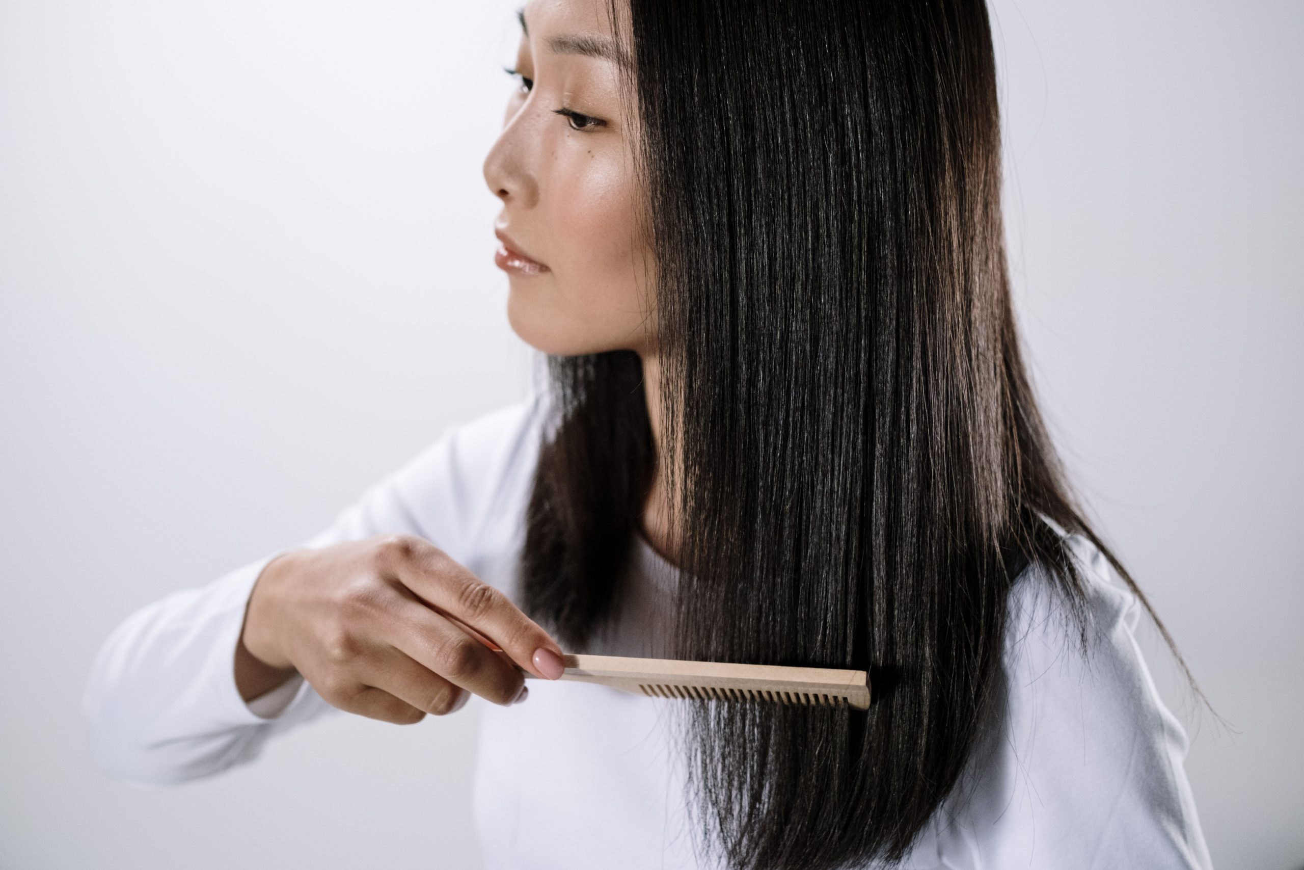 Femme asiatique se coiffant cheveux noirs lisses.