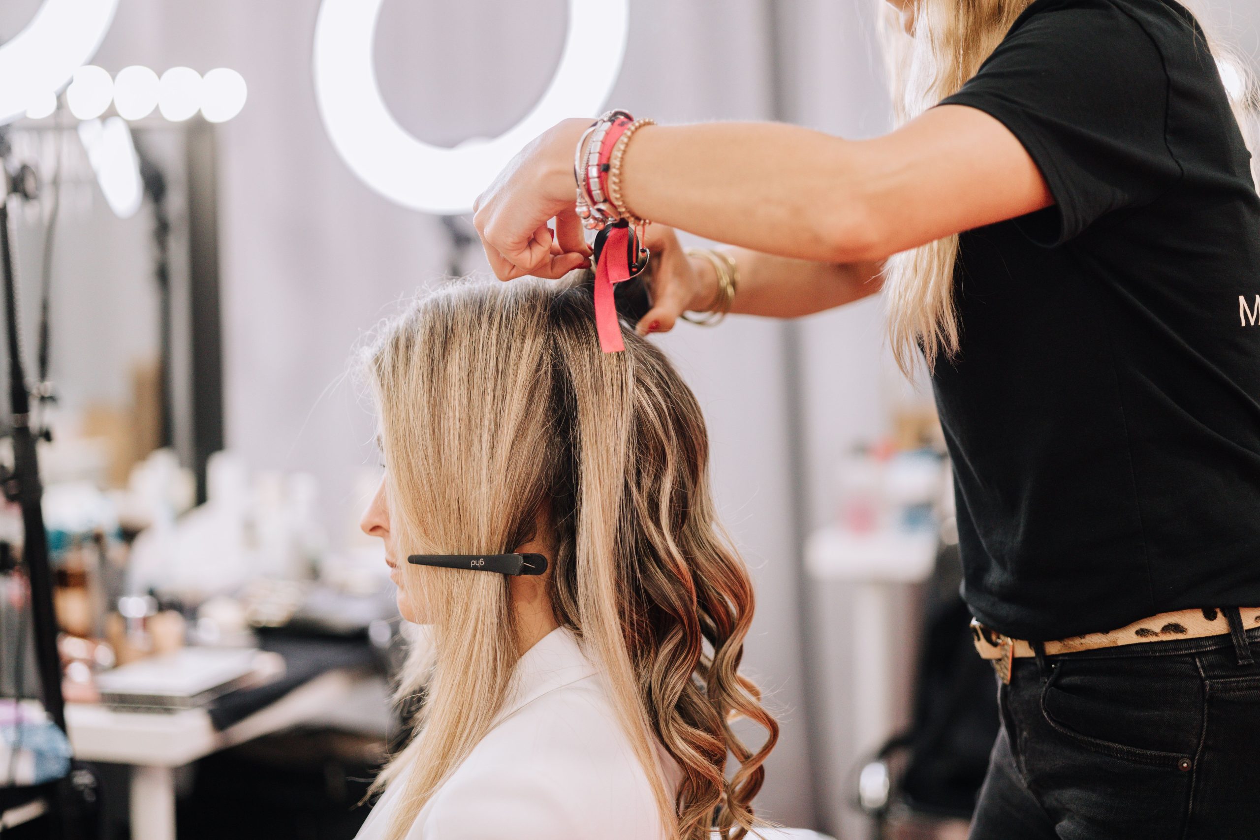 Styliste travaillant sur cheveux blonds en studio