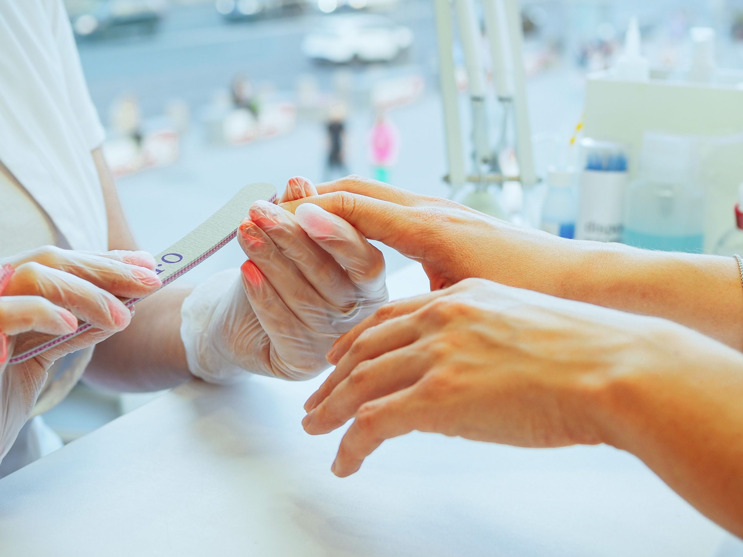 Manucure limant les ongles d'une cliente