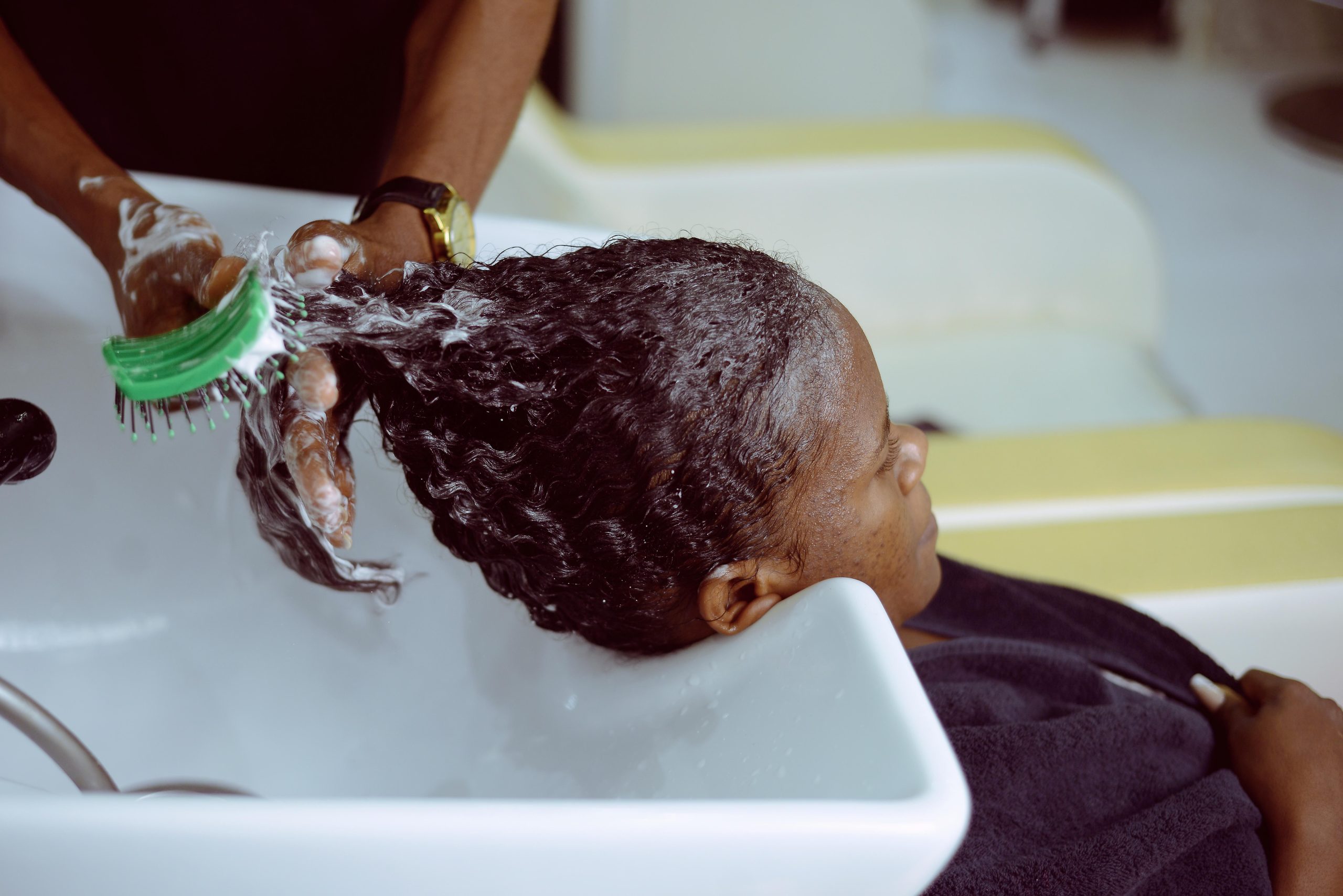 Femme se faisant laver les cheveux avec soin.