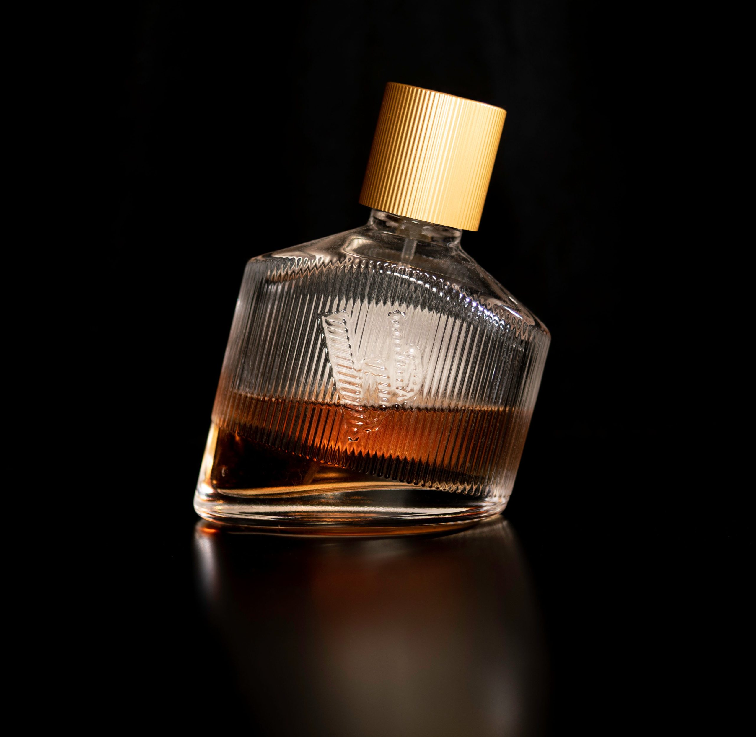 Flacon de parfum incliné avec bouchon doré brillant et luxueux