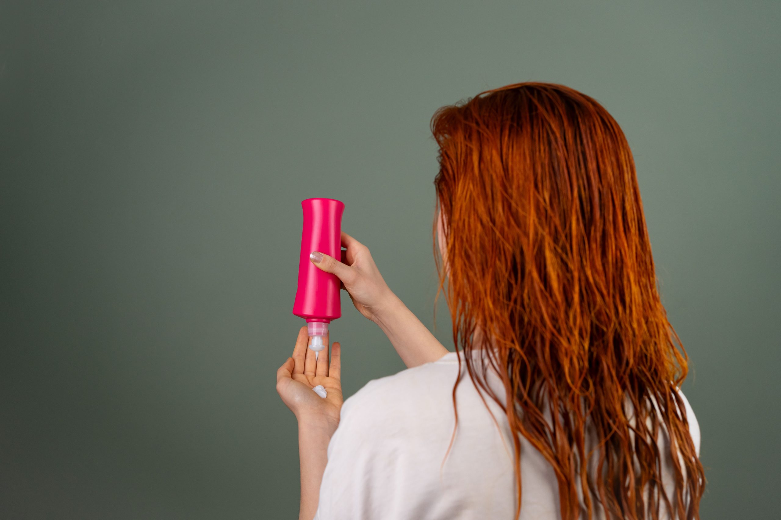 Femme avec cheveux mouilles appliquant apres shampoing