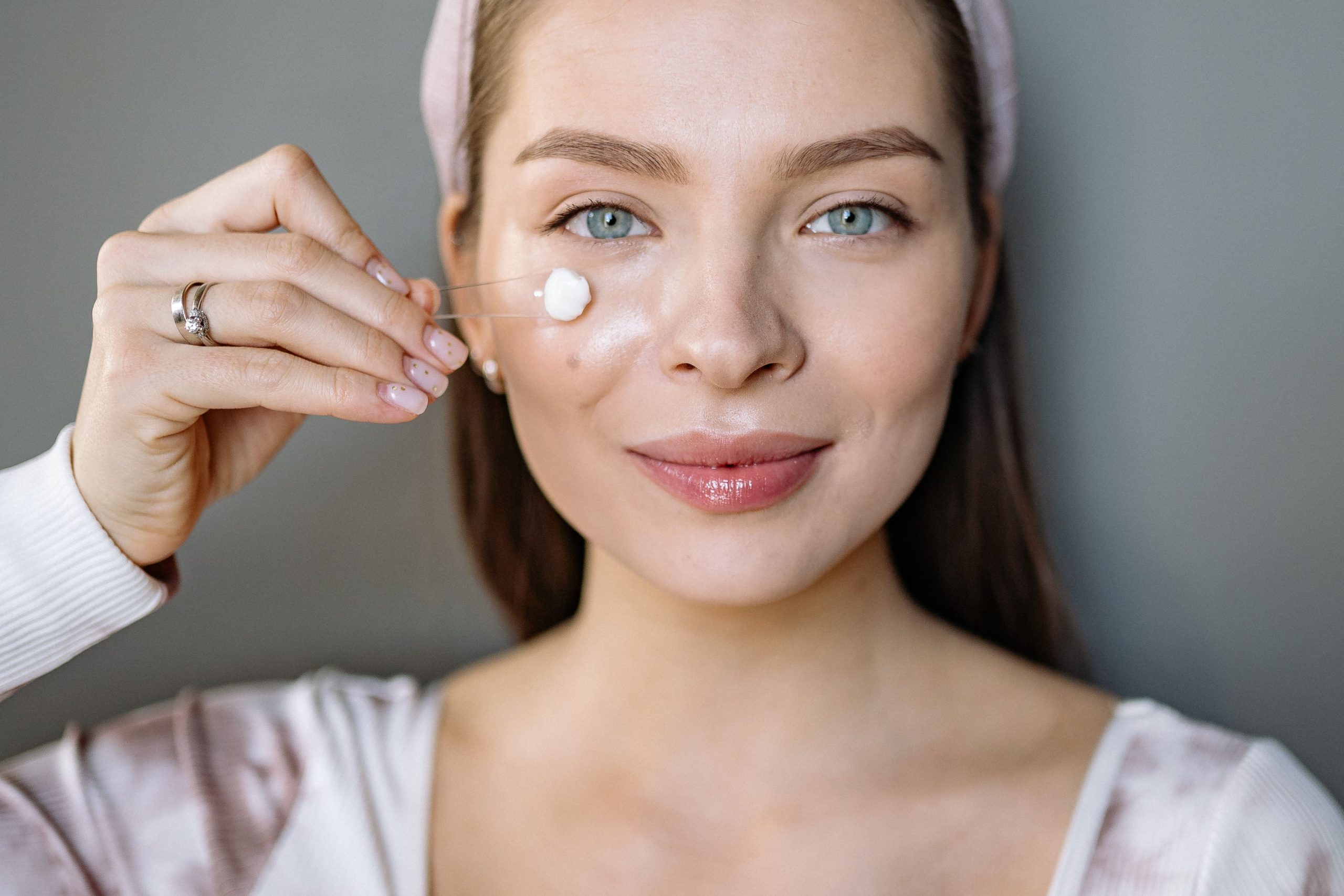 Femme souriante appliquant crème visage