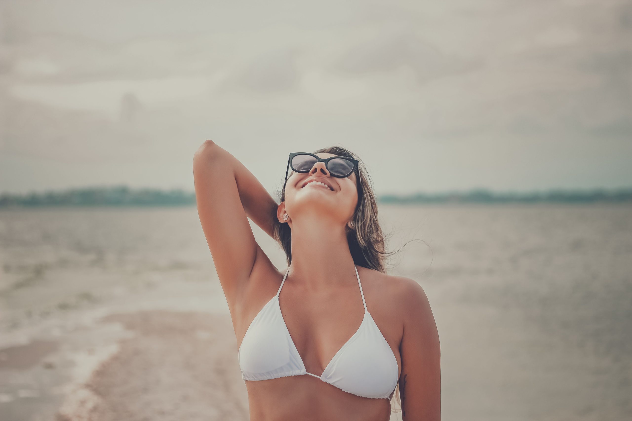 Femme souriante profitant du soleil à la plage