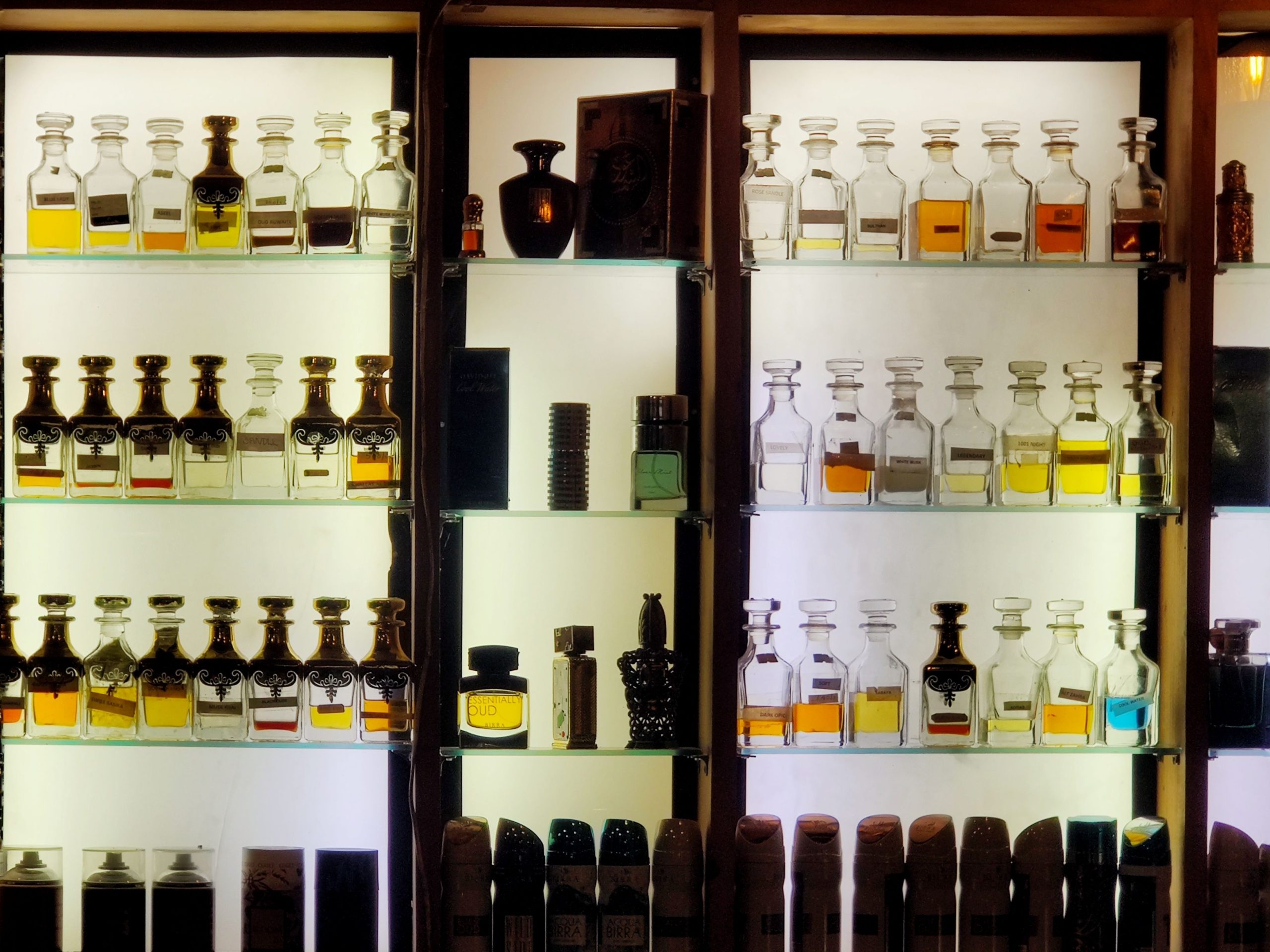 Collection de parfums luxe sur etagere eclairee