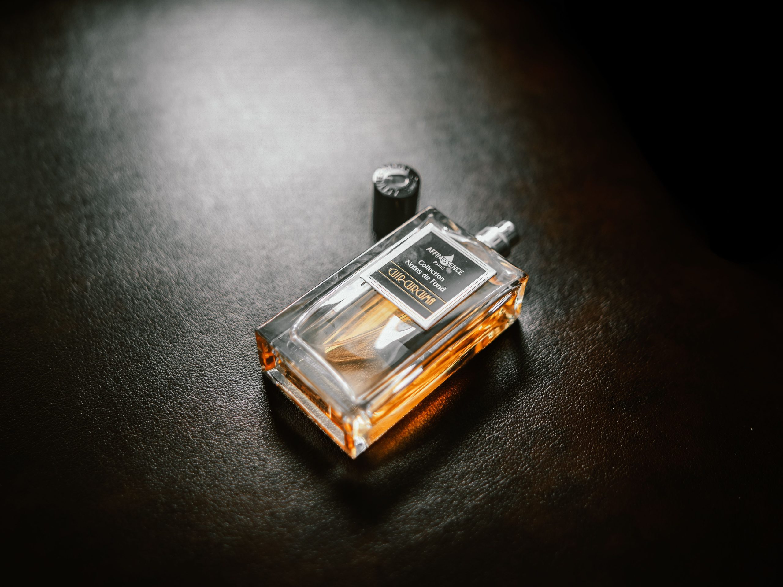 Flacon de parfum luxueux sur fond texturé foncé