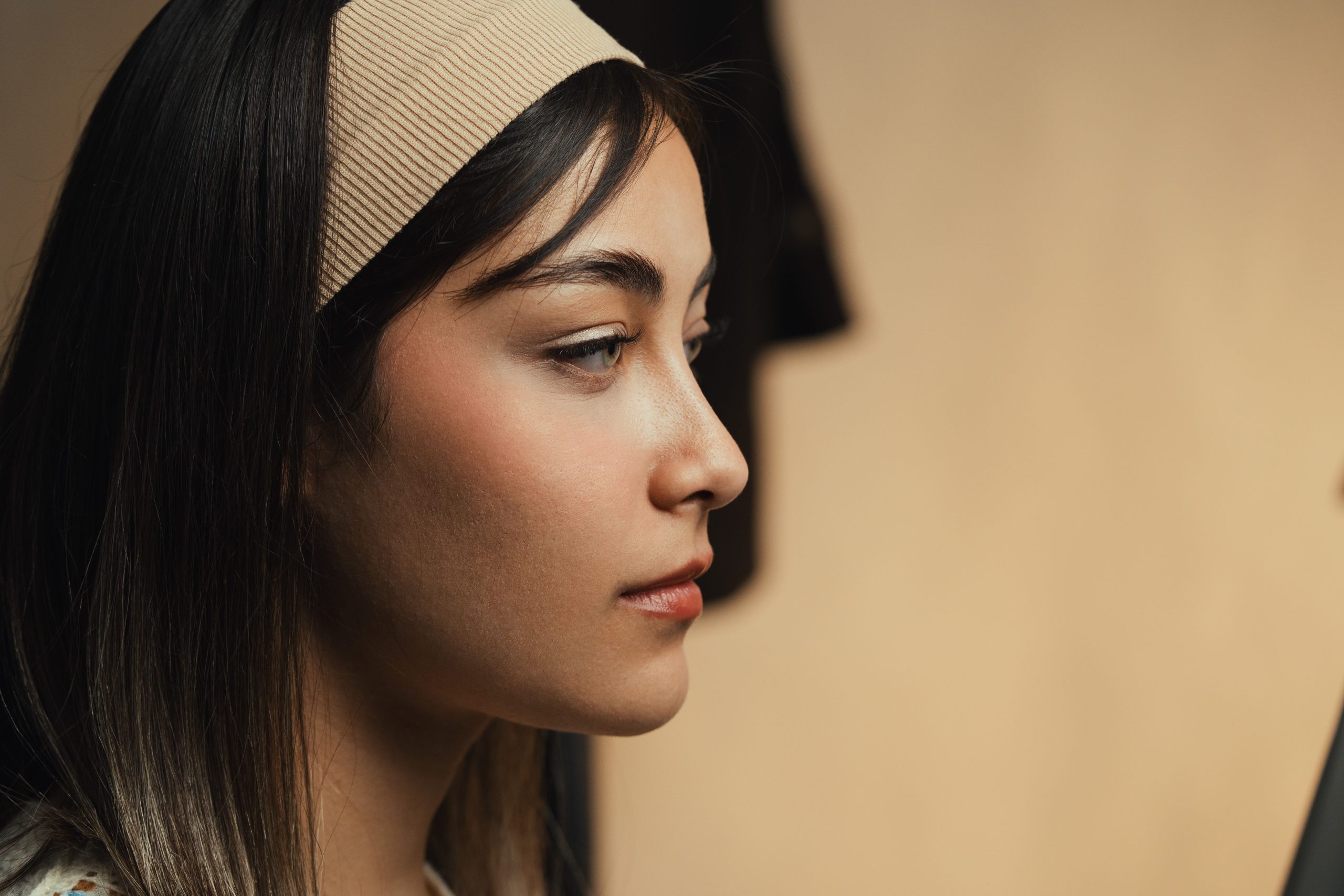 Femme de profil portant un bandeau beige