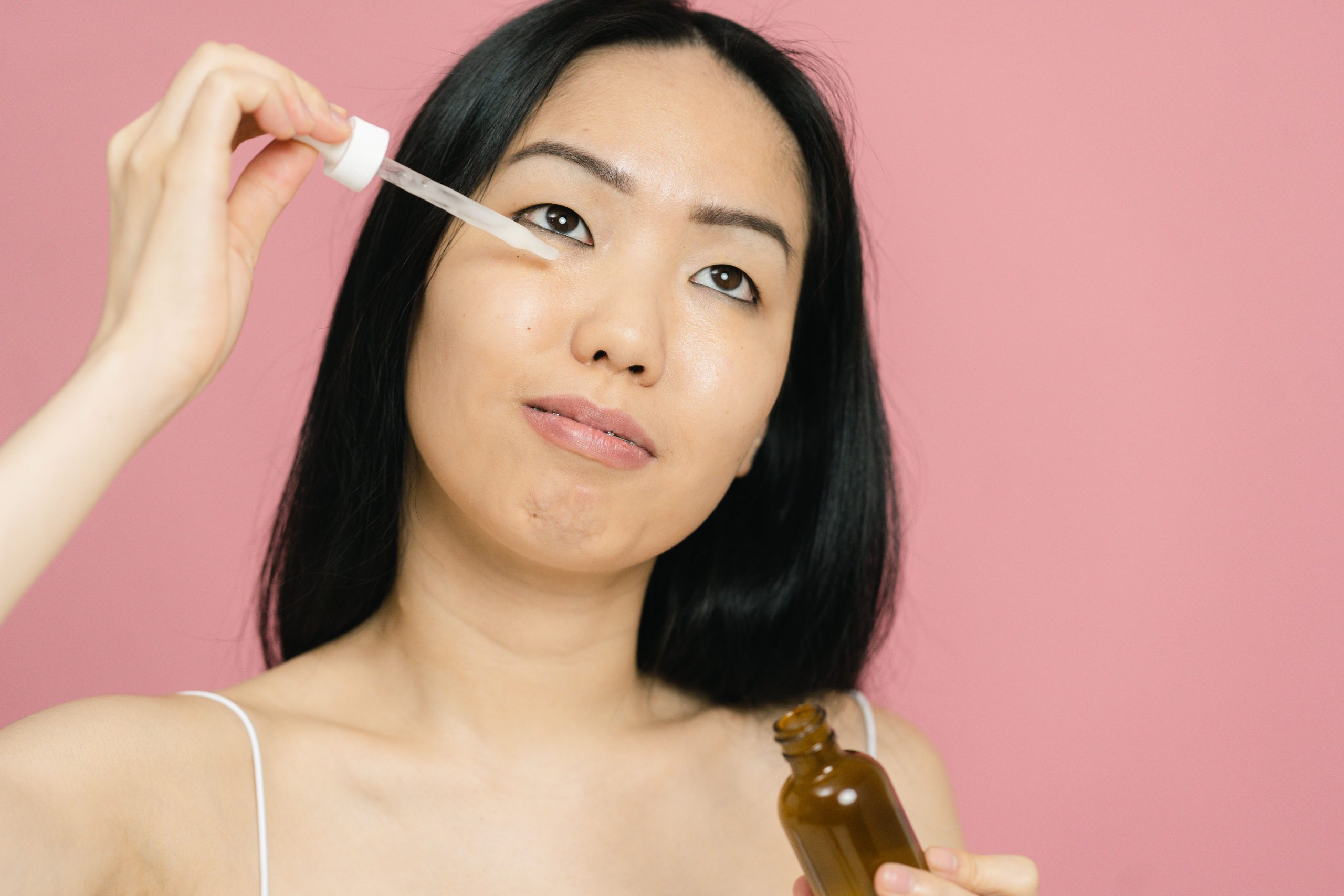 Femme appliquant sérum facial au compte-gouttes